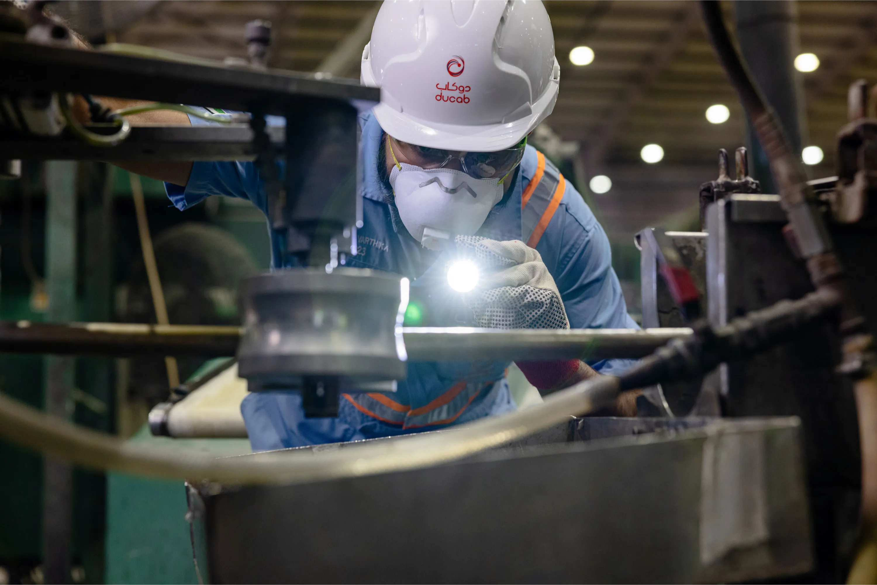 Close-up of Ducab worker operating factory machinery